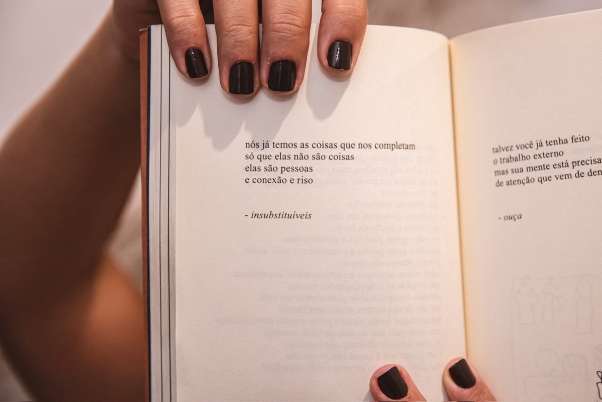 Livro de poesia aberto nas mãos durante um encontro
