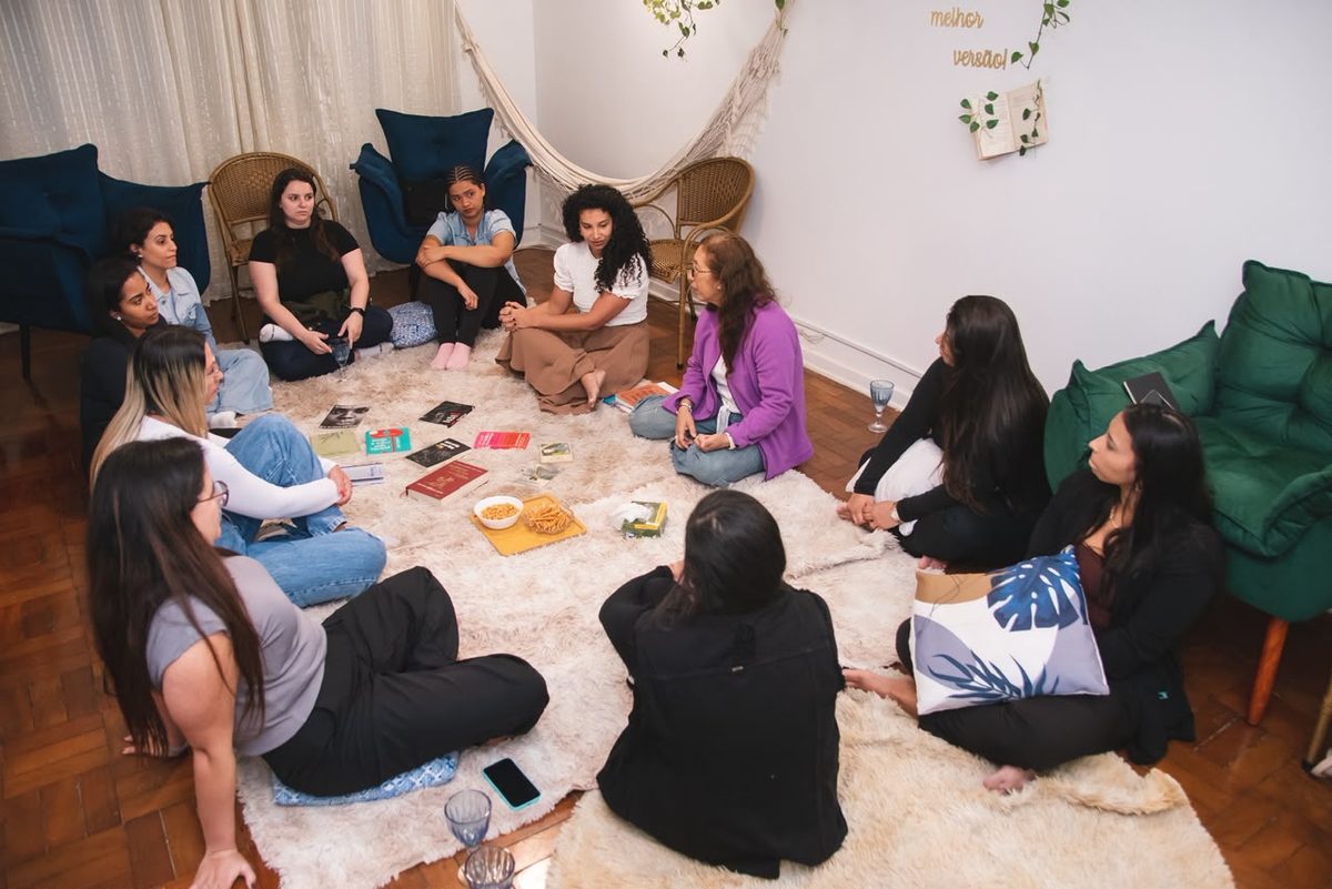 Roda de mulheres sentadas no tapete durante encontro do Grupo EntreNós